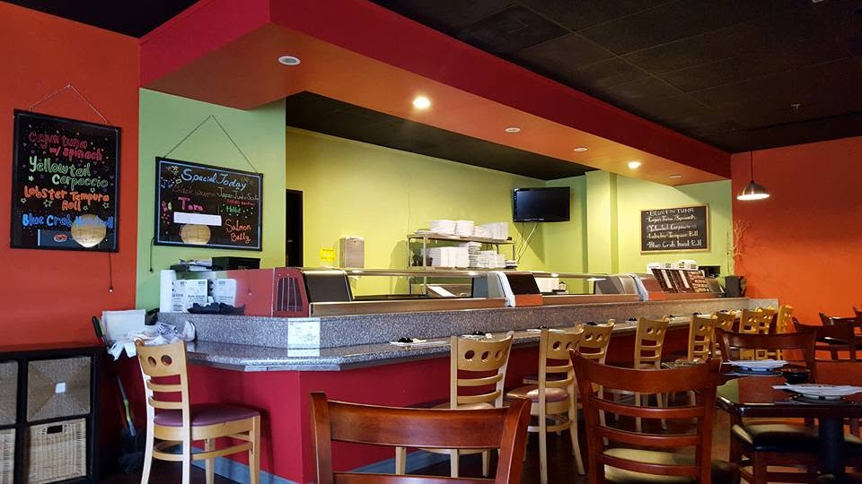 Interior of casual restaurant with red and yellow walls, counter service area, and wooden chairs at dining tables