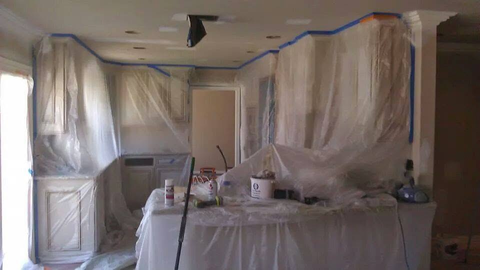 Interior room with plastic sheeting and blue tape masking for painting or renovation work